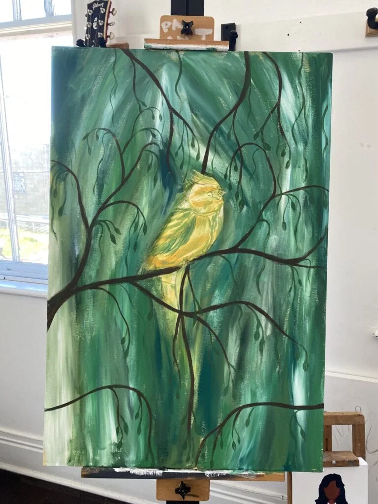 A painting in progress of a bird on a branch