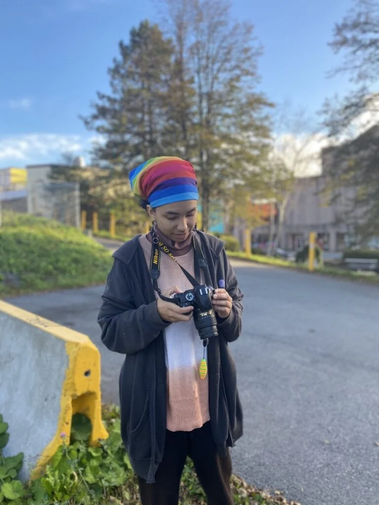 Jayden pauses to look at their previous pictures on their camera screen during a photo walk